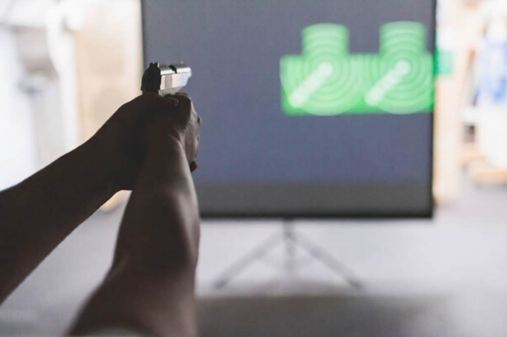 Handgun aimed at a live fire simulator screen